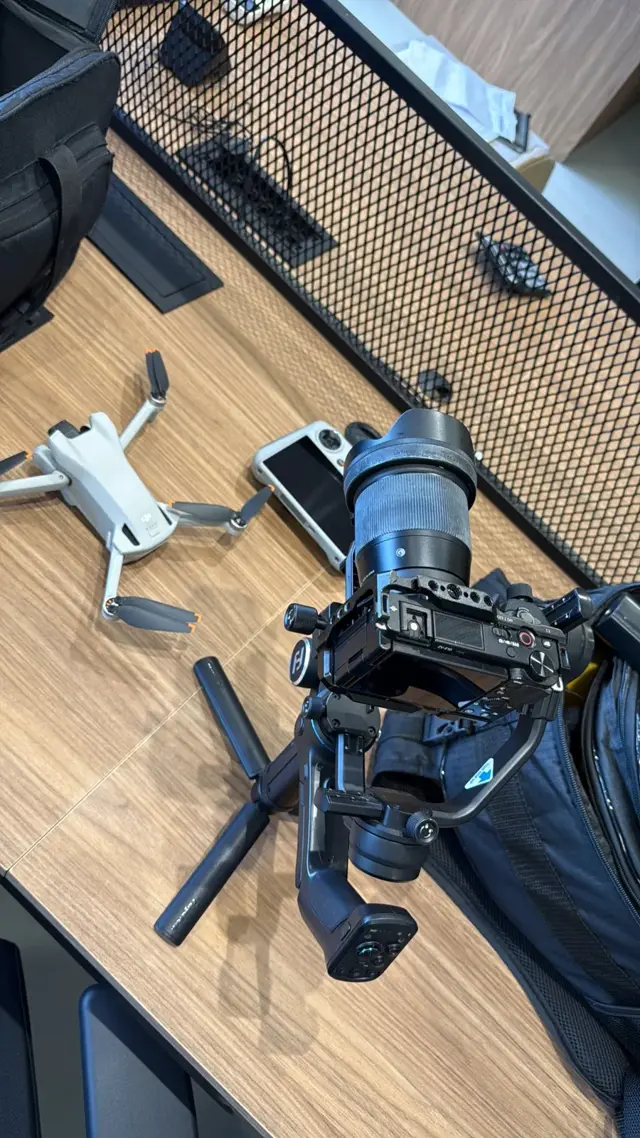 Câmera Sony em estabilizador e drone DJI sobre a mesa